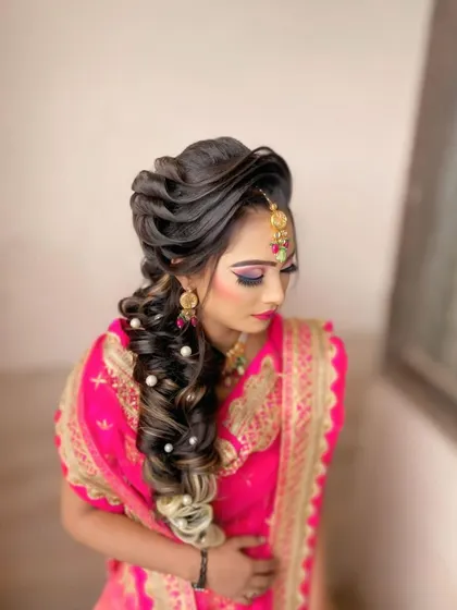 A stunning bridal hairstyle perfect for a wedding or reception. This intricate braid is woven with highlights and decorated with delicate pearls for an elegant and unforgettable look.