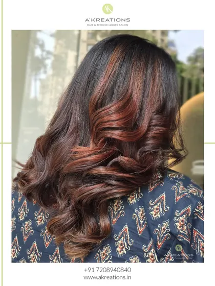 Effortlessly chic balayage with rich, warm tones styled into bouncy curls for a glamorous finish.
