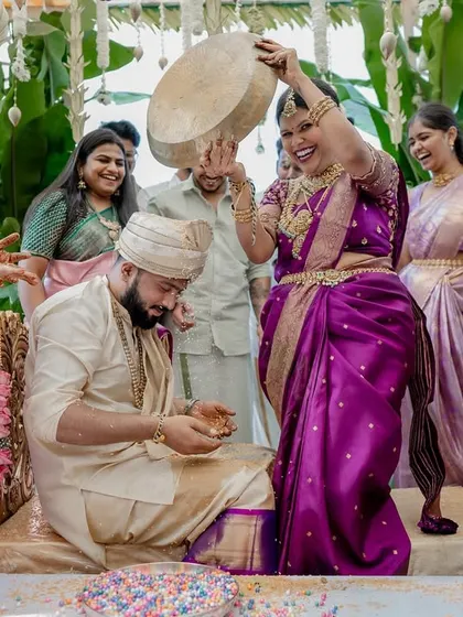 The fun and games of wedding rituals. This moment of laughter during a post-wedding game shows the playful spirit and strong bond between the couple and their families.