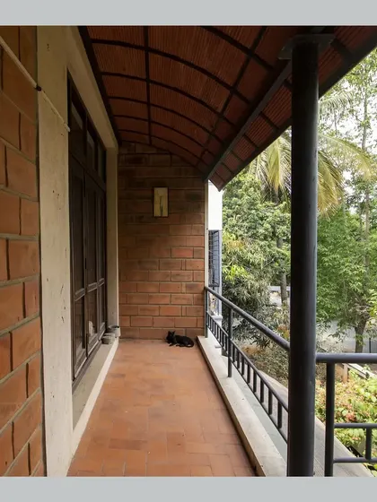 A balcony with a curved Hourdi block roof, offering a sheltered space to relax and enjoy the view of the garden.