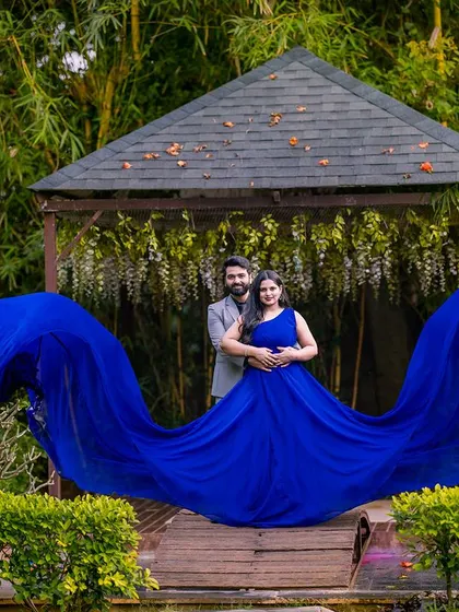 The flowing blue gown creates a beautiful wave-like shape in this shot at the gazebo. It's a classic pose that highlights the elegance and drama of the outfit.