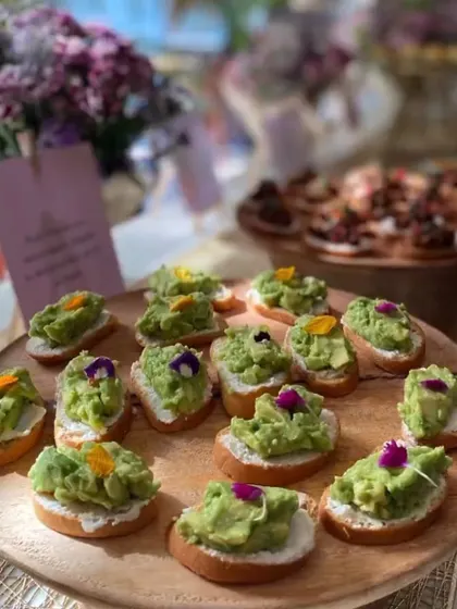 A simple yet elegant appetizer perfect for any celebration. These are my avocado toast canapés, featuring creamy mashed avocado on toasted baguette slices, garnished with delicate edible flowers. They are always a crowd-pleaser.