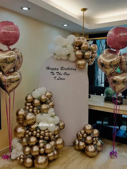 A wider view of the setup, showing the two bouquets of foil balloons that frame the central backdrop.