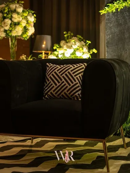 A close-up of the chic black velvet armchair and chevron rug from the Jazz Club cocktail night. Even the furniture is chosen to reflect the theme and create a cohesive, stylish environment for guests.