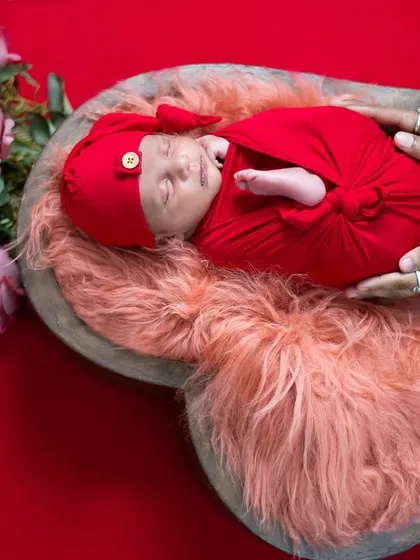 A perfectly wrapped newborn nestled in a heart-shaped bowl. This photo highlights our attention to detail in newborn photography, using soft textures, rich colors, and safe posing techniques to create adorable and artistic baby portraits.