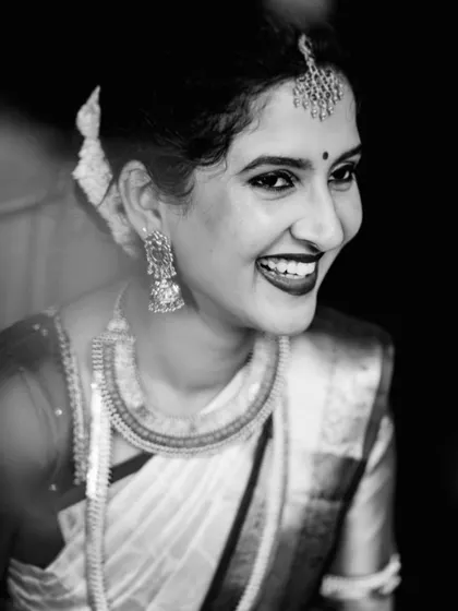 A simple yet stunning black and white bridal portrait. Her joyful, natural smile is the centerpiece of the photograph, creating a classic and happy memory.