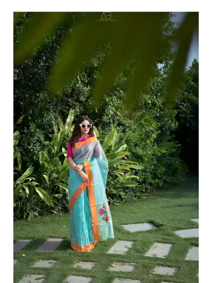 Confidence looks incredible in a saree. This outdoor portrait uses the natural green backdrop to make the light blue saree pop, creating a fresh and stylish look.