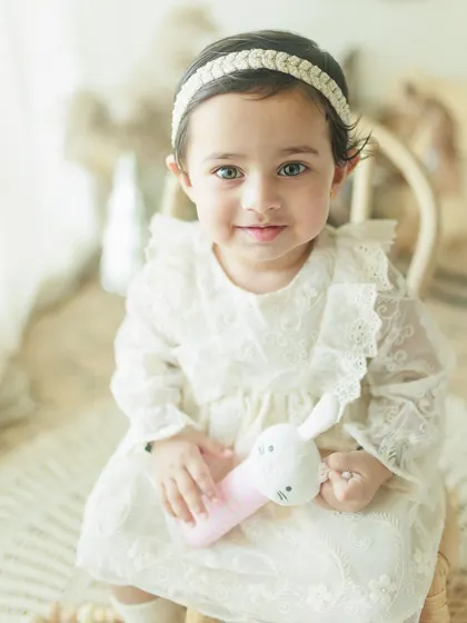A beautiful close-up of a one-year-old girl during her birthday milestone shoot. Her bright eyes and sweet expression are the focus of this lovely portrait.