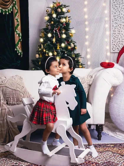 A sweet secret shared between sisters. This photo captures the special bond of siblings during the most wonderful time of the year.