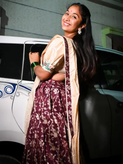 The back view of this cream and maroon Langa Davani shows the beautiful drape of the dupatta and the detailed floral work on the skirt.