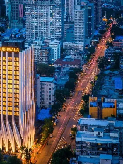 Another perspective of the tower at night, highlighting its relationship with the surrounding urban fabric and the flow of traffic along the street.