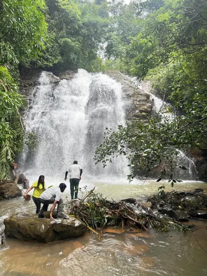 A group of friends at the base of a waterfall, part of our "12 Waterfalls in 4 Days" monsoon road trip. It's an intense but incredibly rewarding journey.