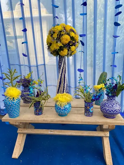 A collection of smaller blue pottery vases, each with a unique design, arranged on a wooden bench as part of the detailed decor.
