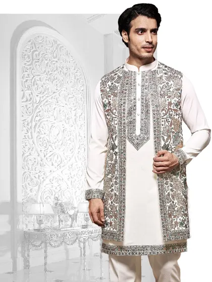 An artistic composition of our craftsmanship. This white kurta is layered with a heavily embroidered open jacket, showcasing a blend of traditional motifs and modern styling.