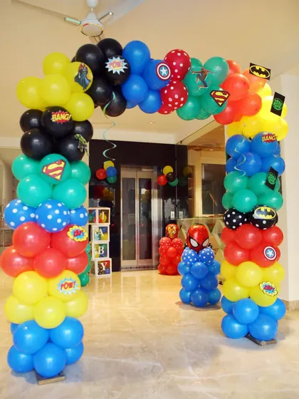 An indoor balloon arch decorated with logos of all the favorite heroes like Batman, Superman, and Captain America. It's a great way to welcome guests into the party zone.