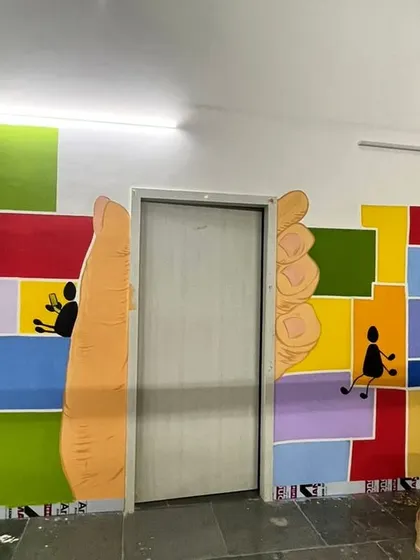 A clever use of a doorway in the Dharavi mural, with giant hands framing the entrance. Art can interact with architecture in the most playful ways.