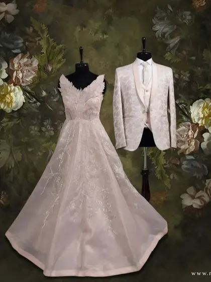 A vision in peach for him and her. The groom's floral textured Italian suit and designer vestcoat perfectly complement the bride's beautifully patterned light peach gown.