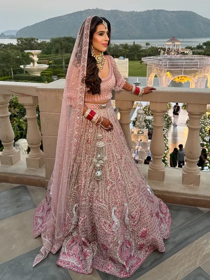 The complete look, with the stunning backdrop of the lake and gardens. The soft pastel lehenga and romantic makeup were a perfect choice for this picturesque wedding setting.