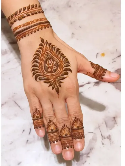 Minimalism can be incredibly striking. This design is perfect for a wedding guest, featuring a central paisley motif with delicate finger and wrist details. It's a quick, modern, and elegant option that still feels special.
