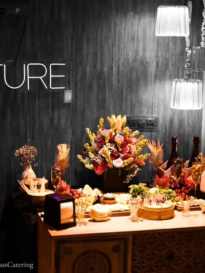 The grazing table set against a modern backdrop with a neon sign. We work with you to ensure our setup complements your event's decor and branding.