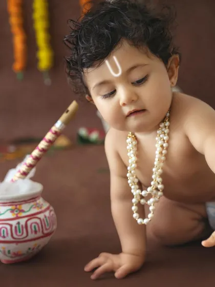 A close-up of a baby's face, with the traditional tilak, capturing the innocence of childhood during a festive shoot.