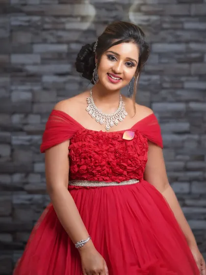 A portrait of a TV actress in a stunning red gown for a designer collaboration. The studio lighting highlights the texture and color of the dress.