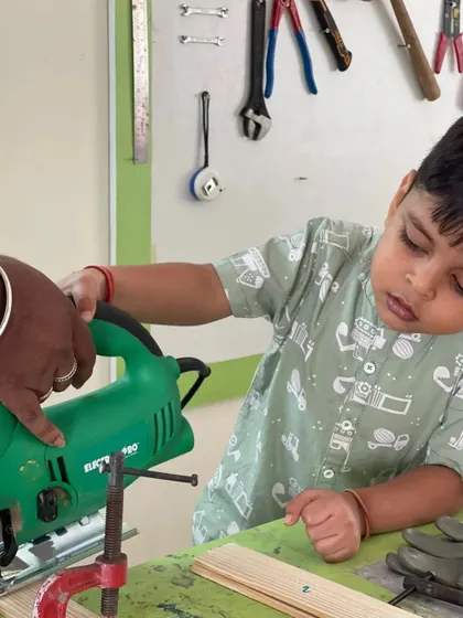 Concentration and care are what we teach. Here, a child gets familiar with a jigsaw, an essential tool in our maker lab for creating more complex wooden designs.