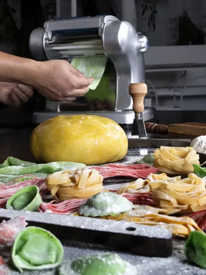 Rolling out fresh pasta sheets and cutting them into various shapes. We offer different types of handmade pasta, from tagliatelle to colourful ravioli.