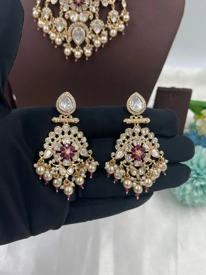 The beautiful chandbali-style earrings from our Ziva and Darbaar necklace sets. These earrings are adorned with pearls and colored stones, making them a popular choice.