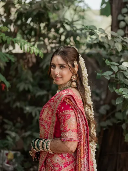 A closer view of this bride's radiant look. Her skin is glowing, and the eye makeup is soft yet defined. The traditional green bangles and pink saree create a beautiful color story.