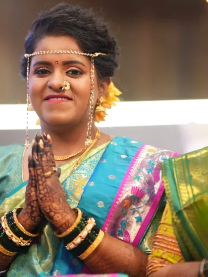 That special mehendi glow. This happy bride is all smiles during her wedding ceremony, with her beautifully stained hands in a traditional namaste pose.