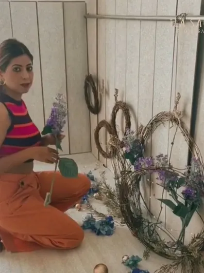 Here I am, barefoot on the floor, putting the finishing touches on a floral wreath backdrop. I'm involved in every creative detail of the shoot.