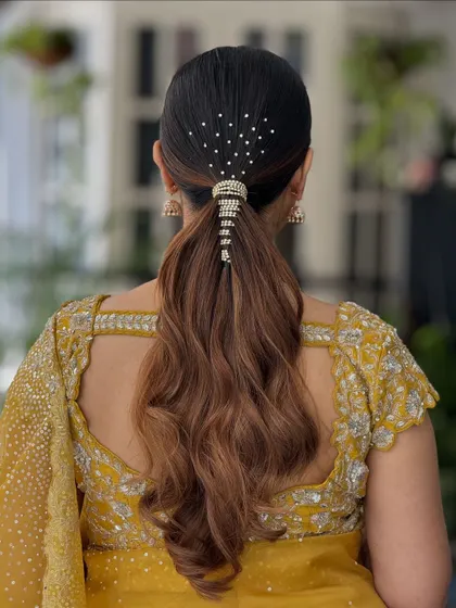 This classic low ponytail is perfect for a reception or cocktail party. It's elegant, modern, and keeps the focus on the bride's beautiful outfit.