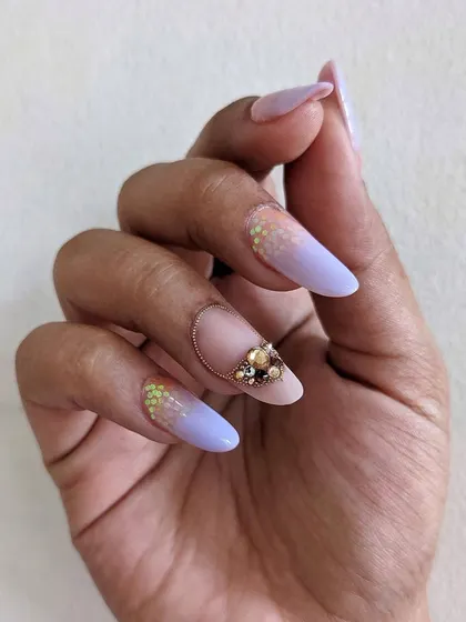 This design combines a soft lavender ombre with a delicate crystal arrangement. The accent nail features a beautiful cluster of gold and iridescent Swarovski crystals, creating a truly luxurious effect.