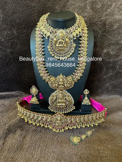 This is a grand Lakshmi bridal set with a double-pendant long necklace and a matching choker. The set is finished with an antique gold look.