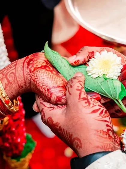A detailed shot of the Hasta Milap ritual, where the couple's hands are joined together, symbolizing their union.