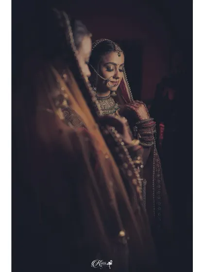 A bride looking at her reflection in a mirror, a classic and introspective getting-ready shot.