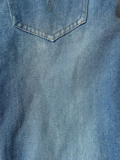The texture and light fading on a pair of custom-made blue jeans, showing the quality and character of the denim I use.