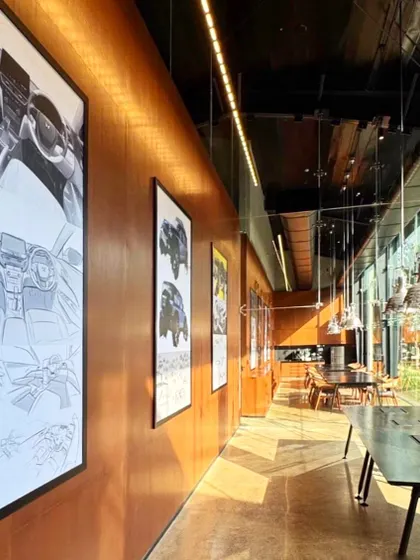 The collaborative spaces in the Automobile Design Studio are designed to inspire. A long gallery wall with warm wood paneling displays automotive sketches and renders, creating a space for informal reviews and discussions that is steeped in the language of design.