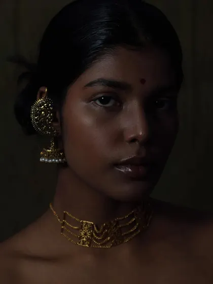 I love playing with shadows and low-key lighting to create something truly artistic. This portrait uses a painterly approach to light, sculpting the model's features and highlighting the warm tones of the gold jewelry against her skin. It shows my ability to create deep, moody, and soulful beauty images.