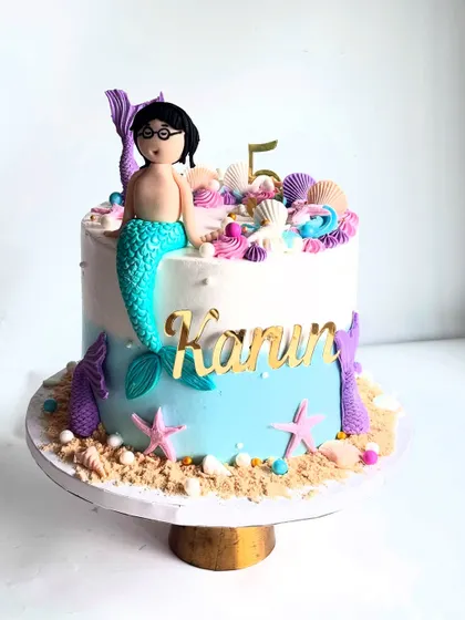 Another angle of the merman cake, showing the custom figurine that looks just like the birthday boy, complete with glasses.