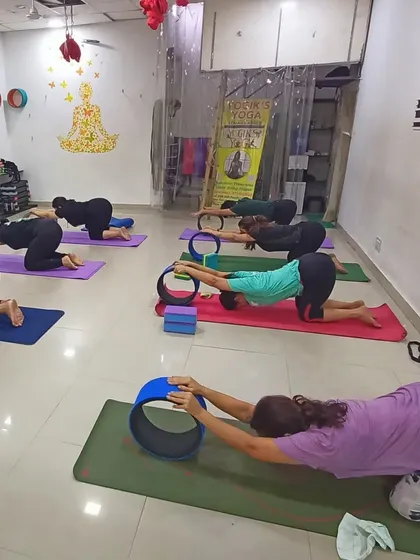 A class in session, using yoga wheels to open the chest and shoulders in Anahatasana (Melting Heart Pose). This supported stretch feels incredible and helps counteract the effects of sitting at a desk all day.