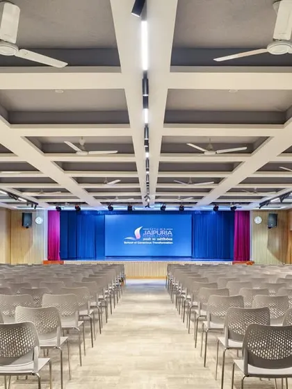 The auditorium was modernized for better acoustics and safety. We exposed the existing coffered slab to maximize height, added new lighting, and installed flexible seating to create a versatile venue for performances and school functions.