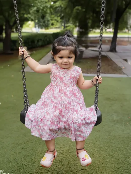 A happy toddler enjoying a swing in the park. This outdoor shot is full of movement and captures the simple joys of childhood.