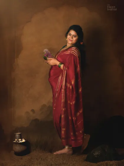 This portrait, inspired by classic paintings, captures a mother-to-be in a beautiful red saree. The earthy tones and traditional props create a serene and artistic celebration of her pregnancy journey.