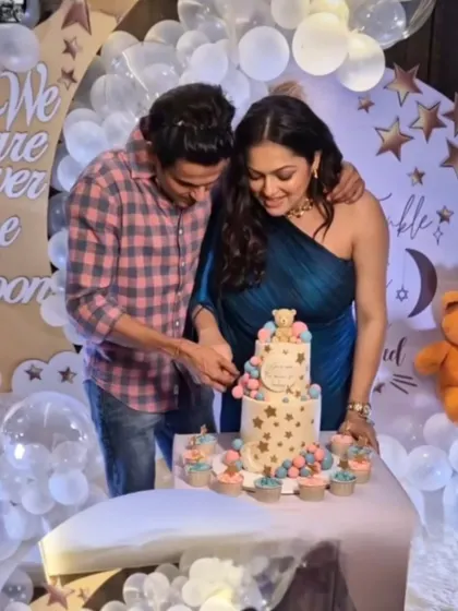 The happy couple, Drashti and Neeraj, cutting their teddy bear themed baby shower cake together.