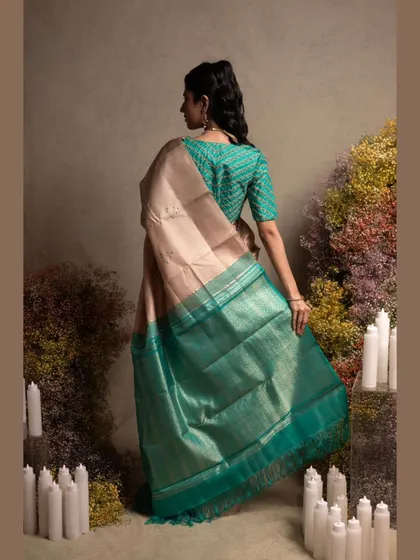A beautiful Kanjivaram in pastel peach and green, paired with an embroidered blouse, showcasing a soft and elegant look.