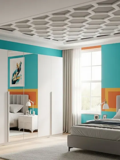 A contemporary bedroom with a bold color scheme, featuring a geometric honeycomb pattern on the false ceiling. The white, multi-door wardrobe includes a mirrored panel that reflects the room's colorful decor.