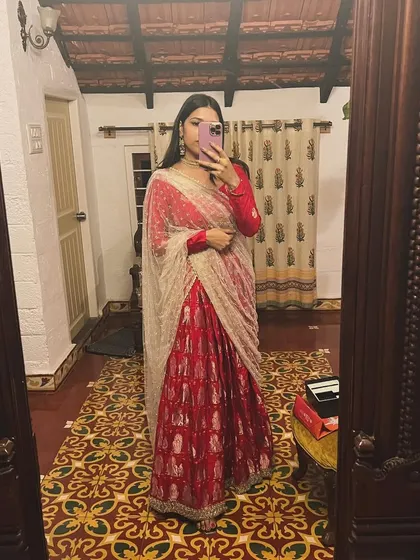 Another look at the stunning red lehenga, showing how it moves and drapes. Creating these special occasion outfits is my passion, ensuring every detail is perfect for you.
