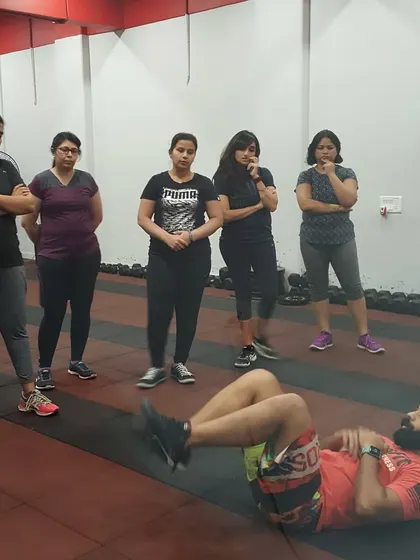 Demonstrating proper ab exercise form to a group of clients. Correct technique is the foundation of safe and effective training.